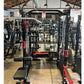 Black and red Warrior cable crossover pulley power rack with lat pulldown attachment in gym facility, front view