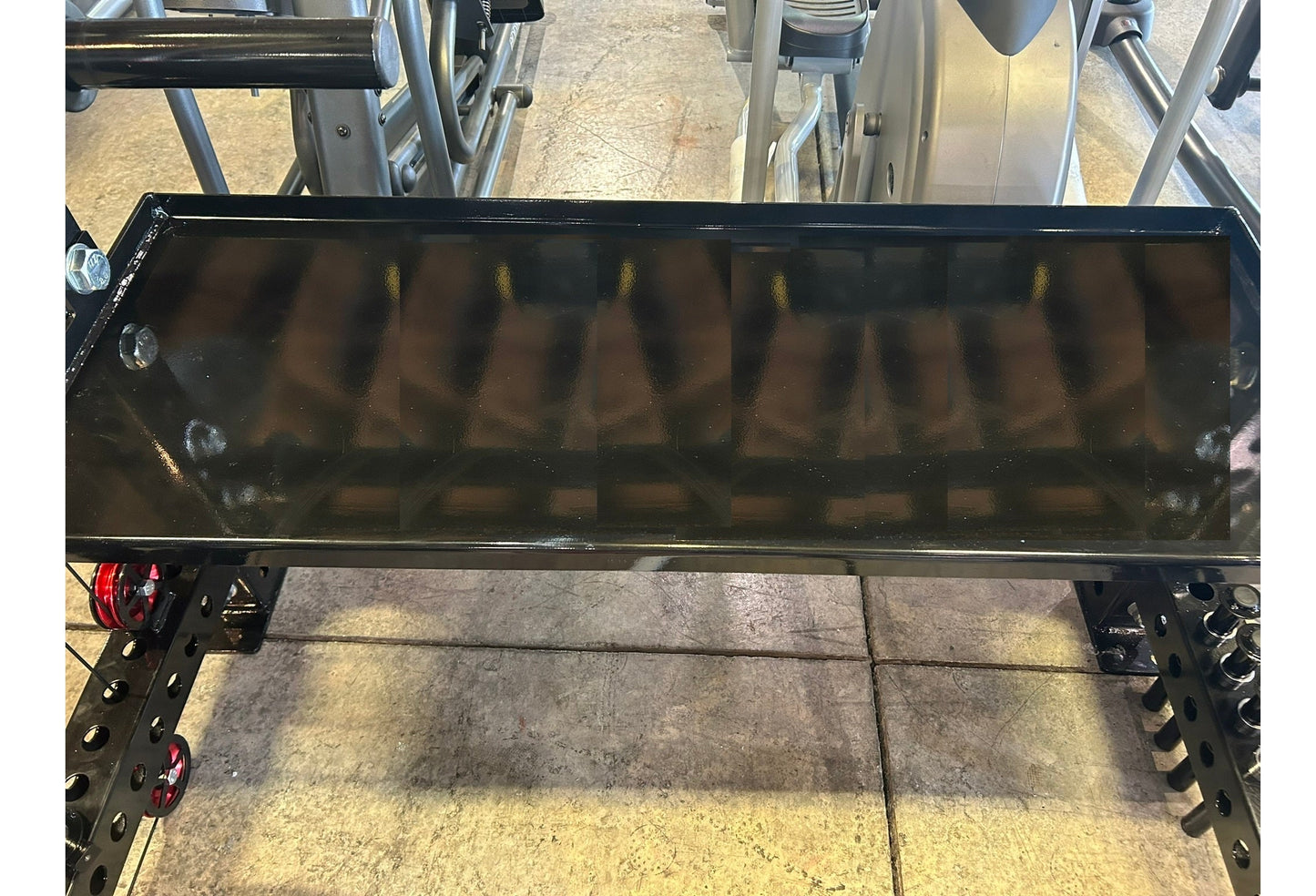 Black steel cable crossover pulley system with lat pulldown attachment mounted on power rack frame, shown in gym setting