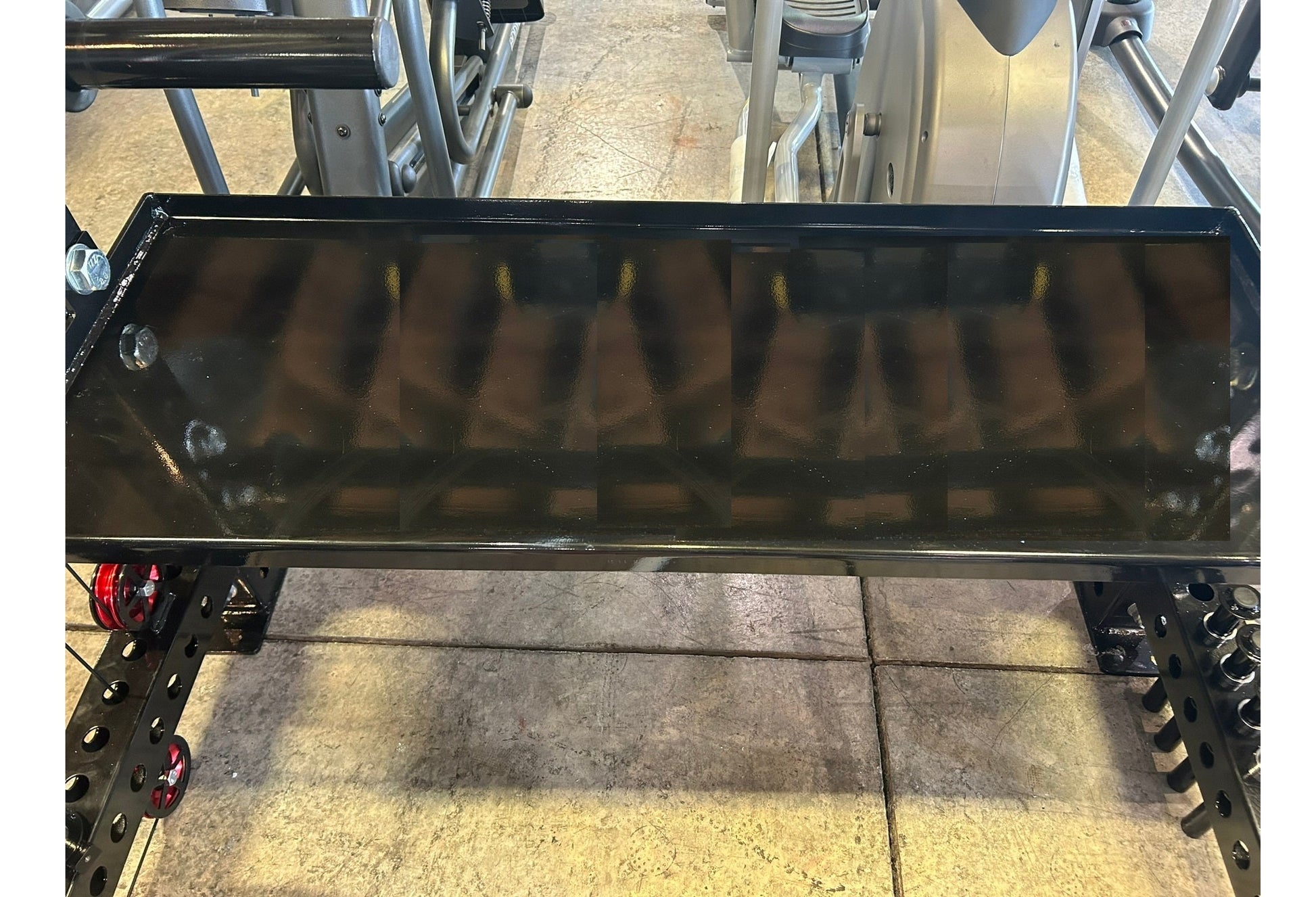 Black steel cable crossover pulley system with lat pulldown attachment mounted on power rack frame, shown in gym setting