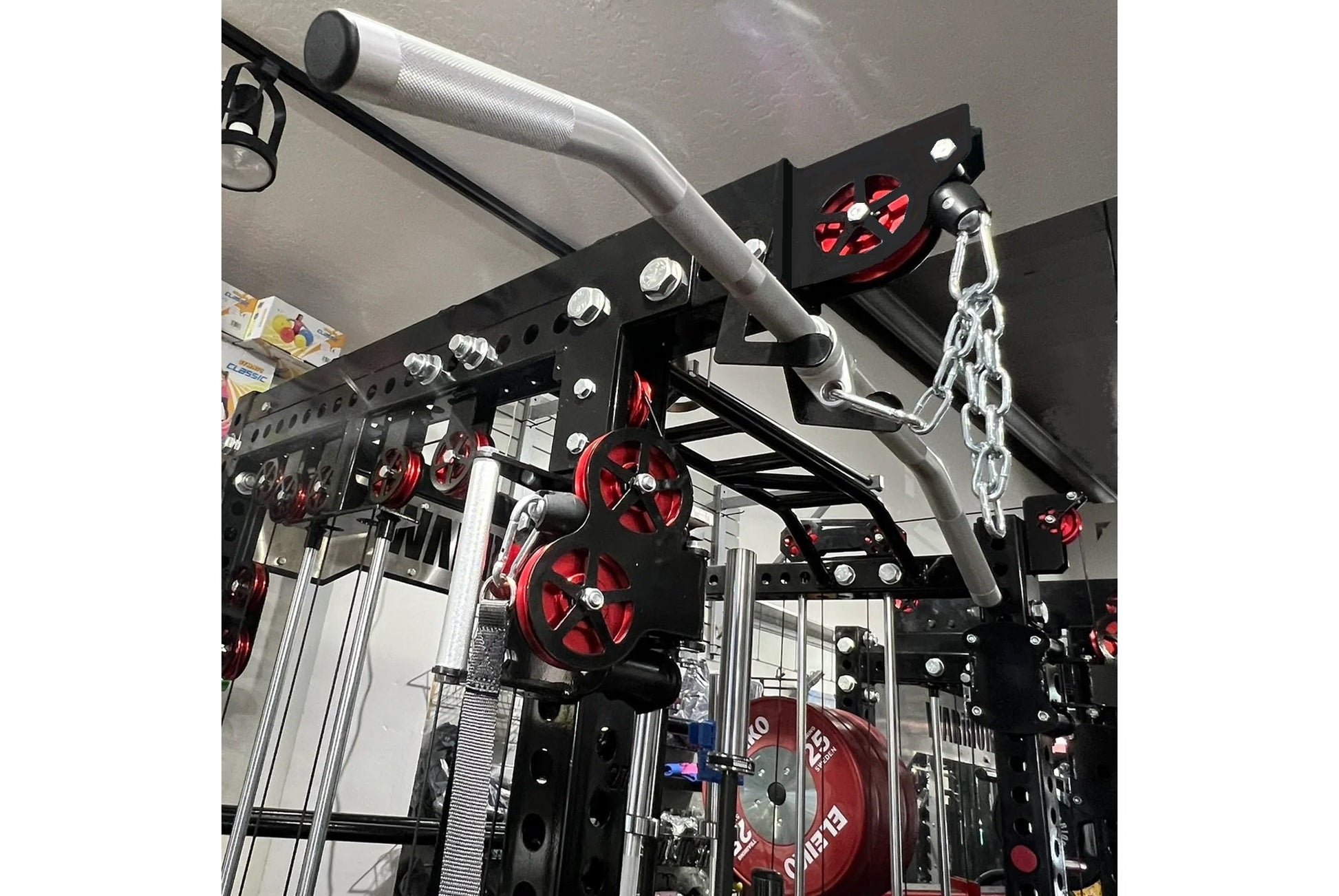 Warrior 3.0 cable crossover pulley power rack with red weight plates and gray pull-down bar on black frame