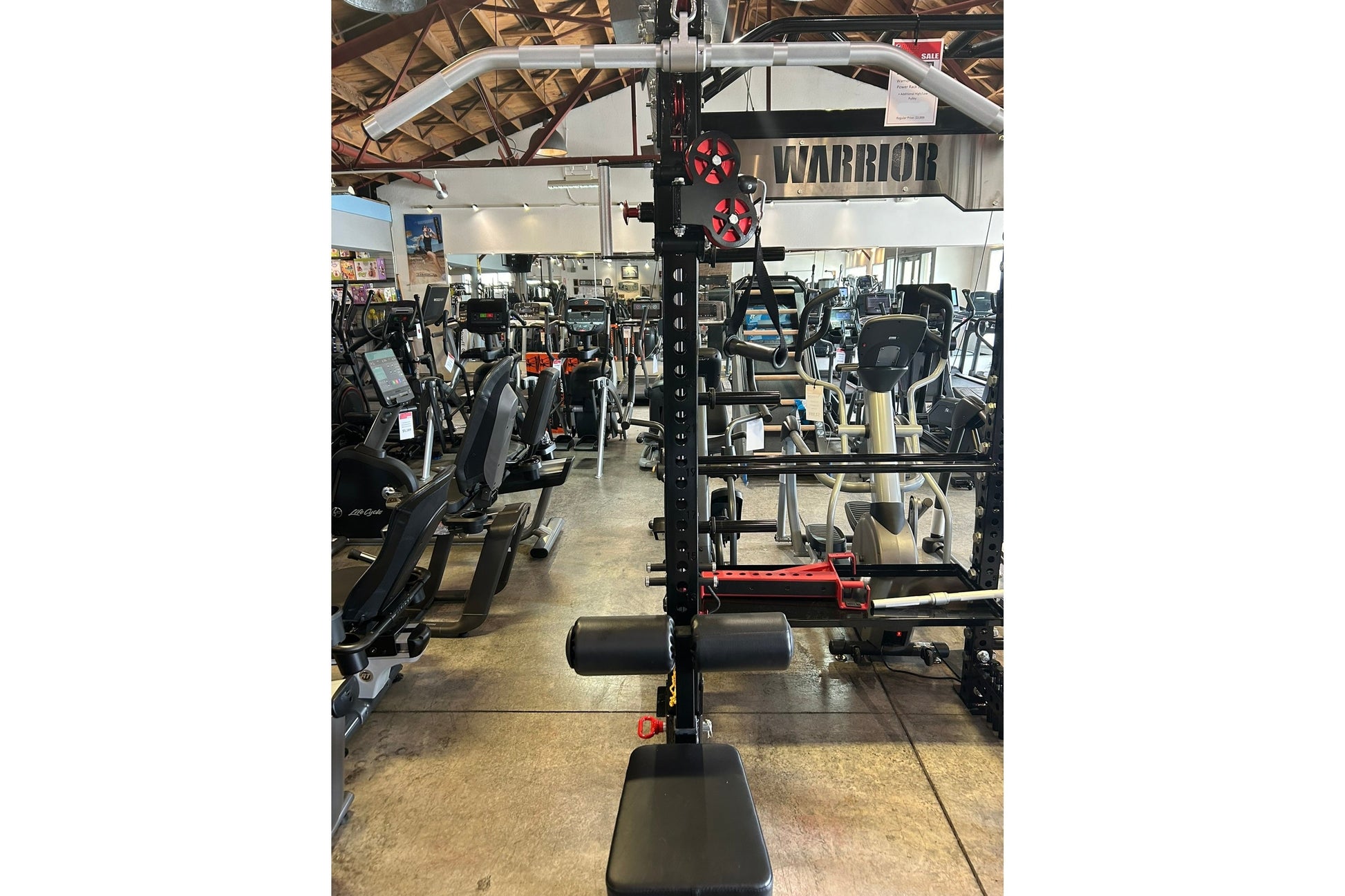 Warrior 3.0 cable crossover pulley power rack with lat pulldown and red accents in gym setting surrounded by fitness equipmen