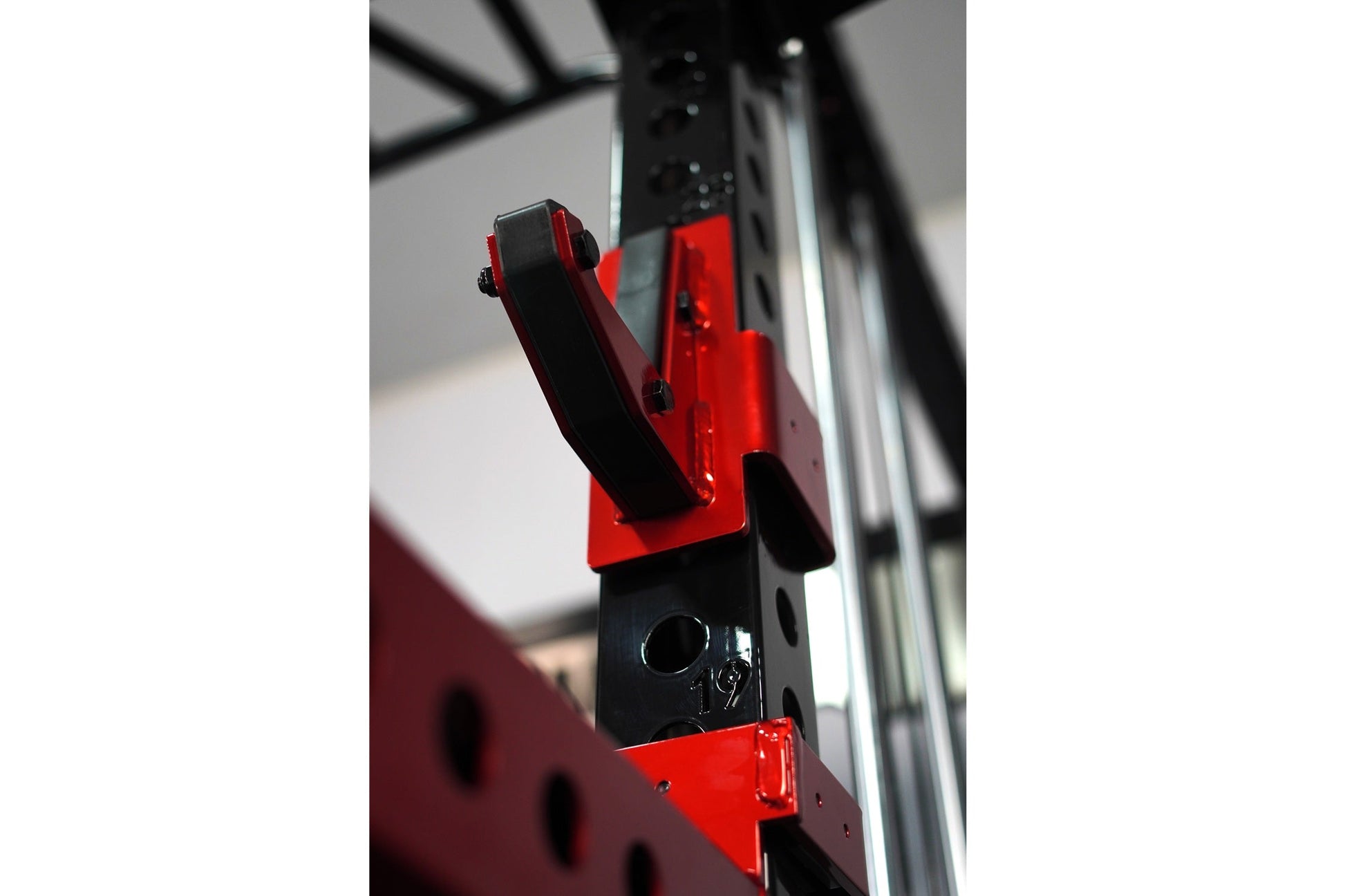 Red and black cable crossover pulley system with adjustable arms mounted on power rack frame
