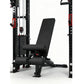 Black and red cable crossover pulley power rack with adjustable black padded bench and leg extension attachment, on white bac