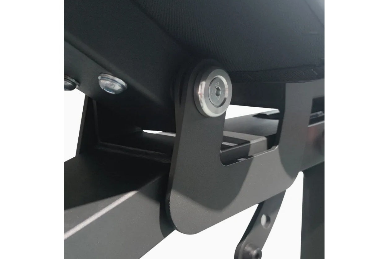 Black and gray adjustable weight bench with leg extension attachment and circular dial mechanism, shown from side angle