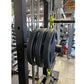 Black weight plates loaded on barbell of Warrior 701 all-in-one power rack with cable crossover in gym setting