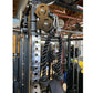 Heavy-duty power rack with dual black twisted cables attached to weight stack, metal frame with hole pattern, and bronze pull