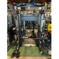 Smith Machine All-in-One power rack with black steel frame, cable pulley system, and adjustable weight pins on green gym floo