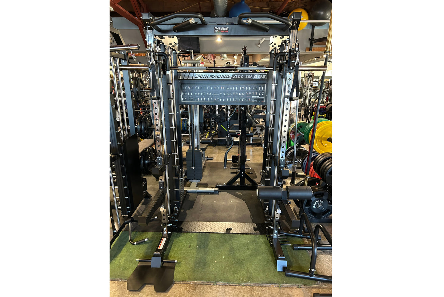 Smith Machine All-in-One power rack with black steel frame, cable pulley system, and adjustable weight pins on green gym floo