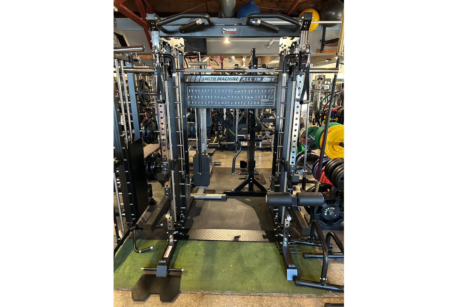 Smith Machine All-in-One power rack with black steel frame, cable pulley system, and adjustable weight pins on green gym floo