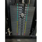 Warrior 901 power rack with stacked weight plates labeled 11 to 198 LBS, color-coded with teal, yellow, and red bands, chrome
