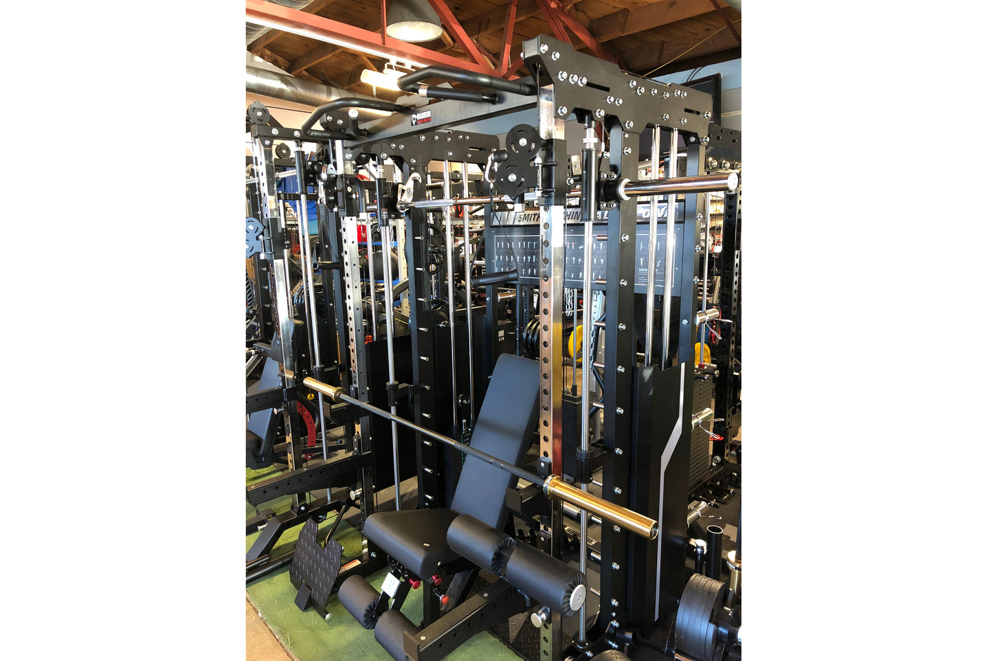 Warrior 901 black all-in-one power rack with integrated cable pulley system, smith machine, and blue padded seat in gym setti