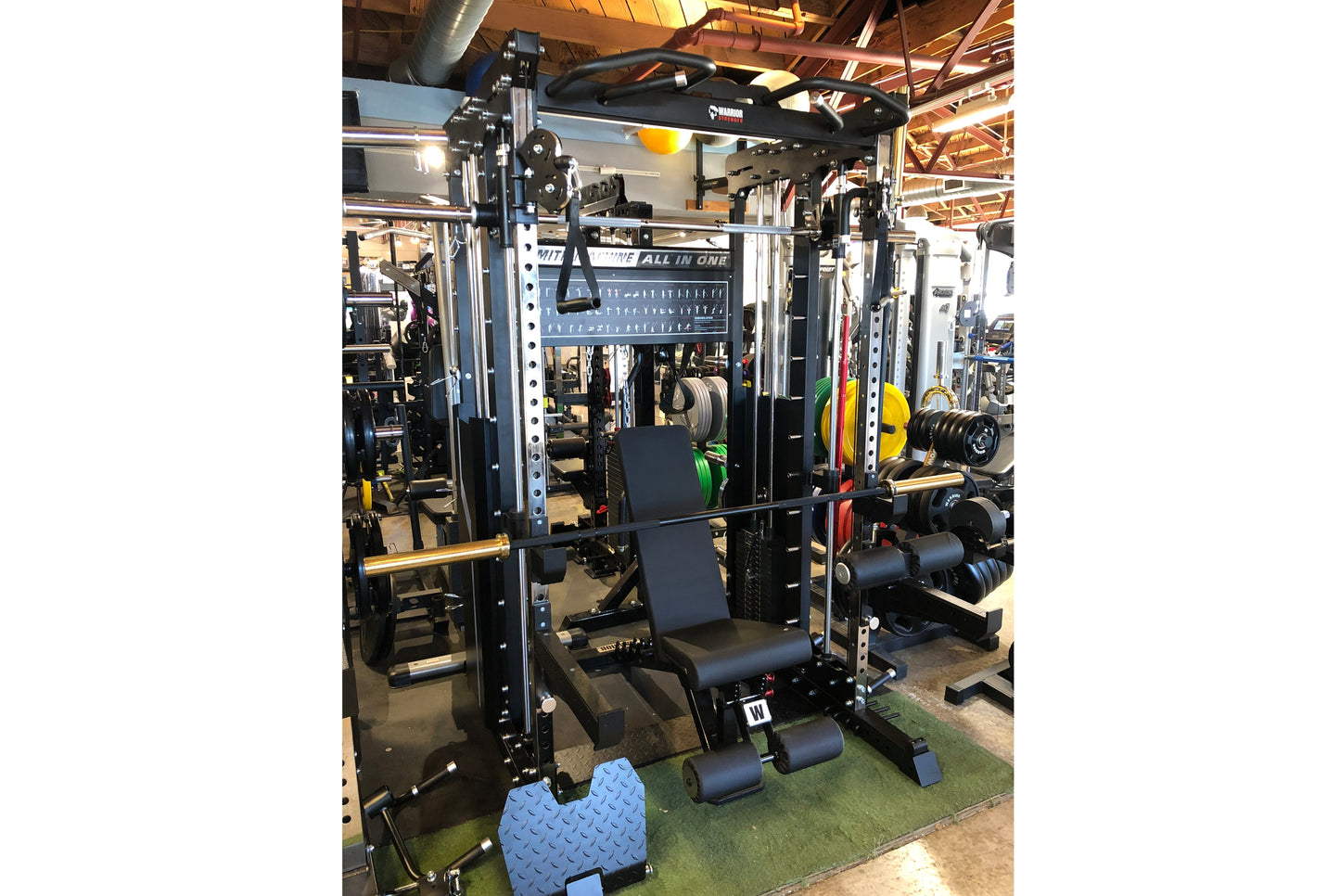 Black and silver multi-station power rack with integrated cable machine, smith machine, and leg press attachment in gym setti
