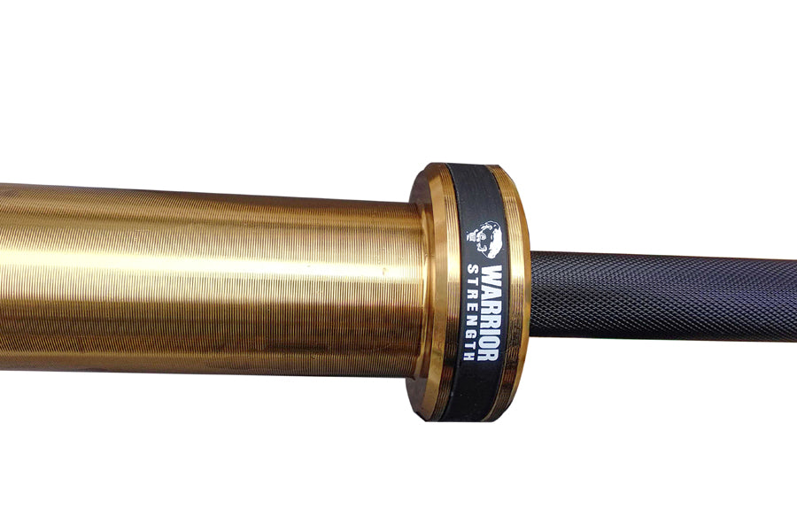 Warrior Black Cerakote & Gold Titanium Barbell with black knurled grip sleeve and branded collar, isolated on white backgroun