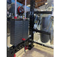 Black cable crossover pulley system mounted on power rack with red accents and weight plate stack, in gym setting
