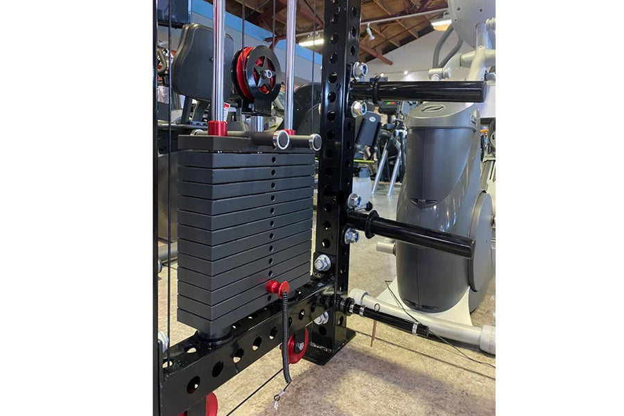 Black cable crossover pulley system mounted on power rack with red accents and weight plate stack, in gym setting