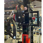 Warrior 3.0 cable crossover pulley system with black pulleys, red accents, and lat pulldown attachment in gym setting