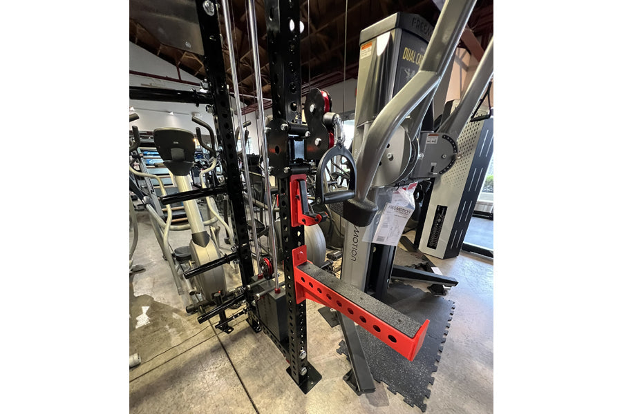 Warrior 3.0 black and red cable crossover pulley power rack with lat pulldown attachment in showroom setting