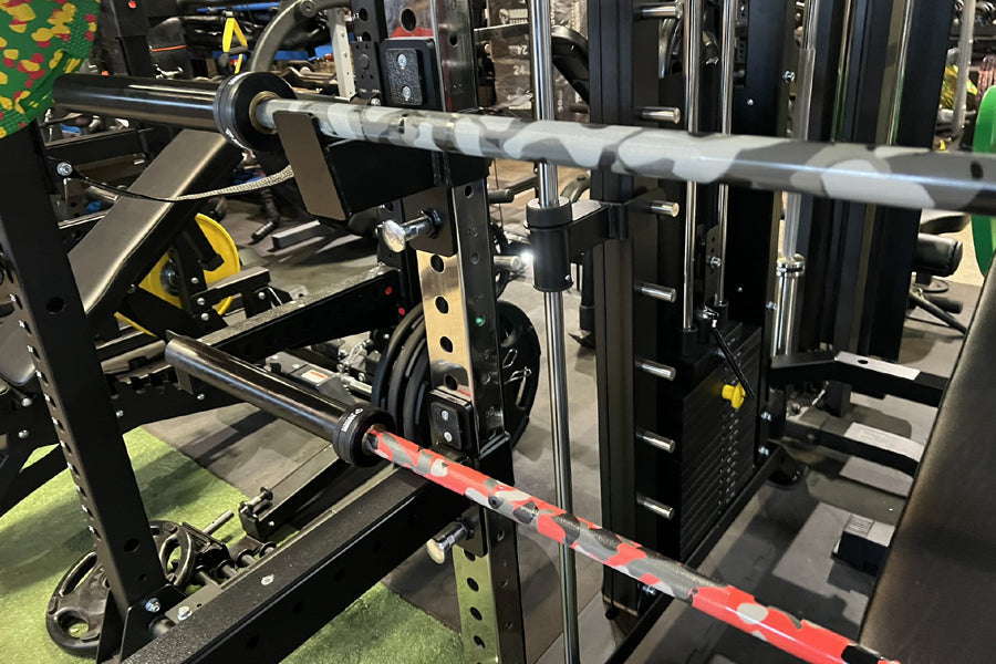 Warrior 6-bearing cerakote barbell with gray camo finish in squat rack, flat lay view