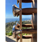Wooden and stainless steel dumbbell with coastal ocean view in background