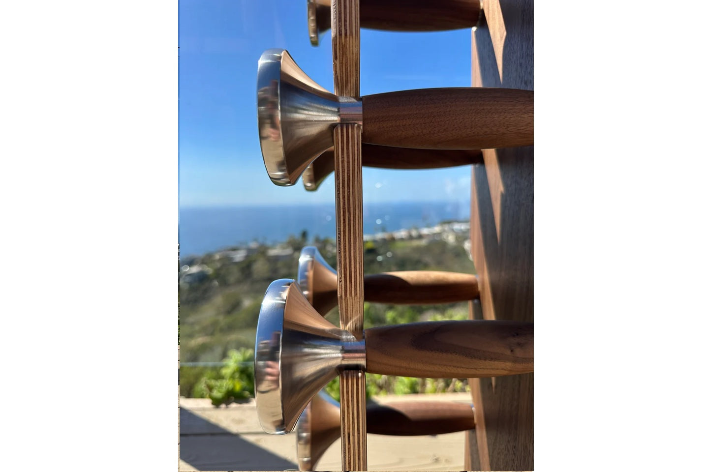 Wooden and stainless steel dumbbell with coastal ocean view in background