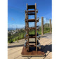Warrior Luxury Wood dumbbell set with stainless steel handles displayed vertically on wooden base, outdoors on deck