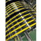 Stacked yellow and black Olympic weight plates with chrome finish and white grip markings on industrial shelf
