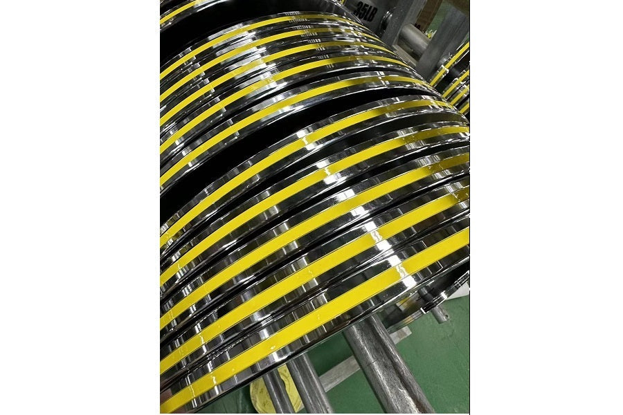Stacked yellow and black Olympic weight plates with chrome finish and white grip markings on industrial shelf