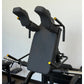 Black padded V-squat machine with dual padded shoulder supports, yellow adjustment knobs, and black metal frame on white back