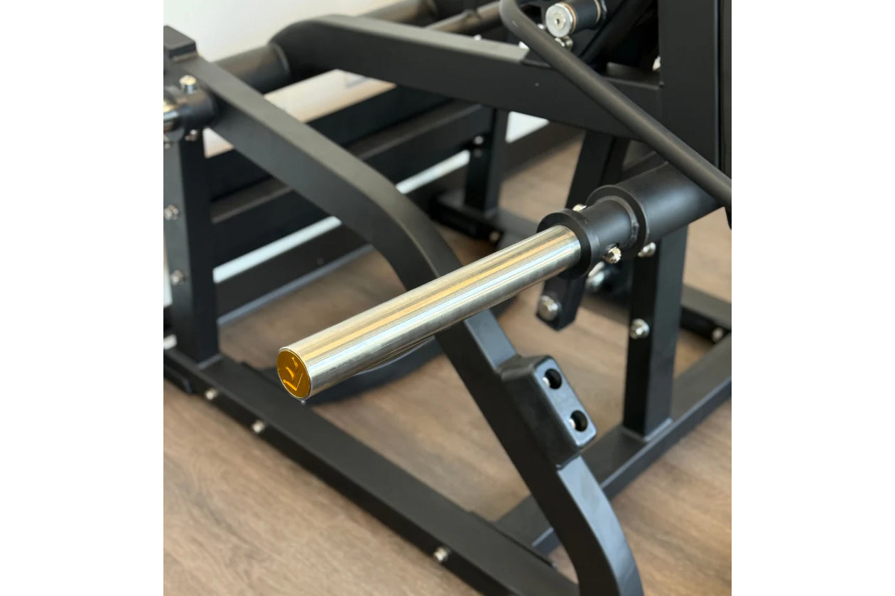 Black metal V-squat machine with polished chrome bar, padded shoulder rest, and adjustable seat on wooden floor