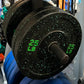 Black speckled bumper plate with green 25 LB markings, loaded on barbell in gym setting