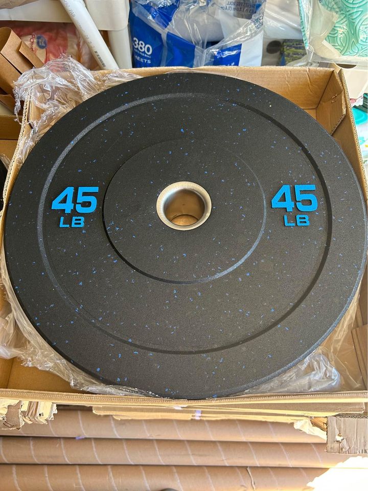 Black rubber bumper plate with blue speckles, 45 lb weight marked in blue text, metal center ring, in cardboard box