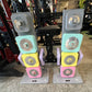 Pair of Warrior D22.5 adjustable dumbbells with stacked colored plates in gray, turquoise, yellow, and pink on display stands