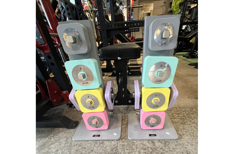 Pair of Warrior D22.5 adjustable dumbbells with stacked colored plates in gray, turquoise, yellow, and pink on display stands
