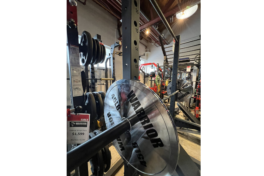 Warrior Deluxe Squat Rack with loaded barbell and weight plates in gym setting