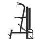 Black commercial assisted chin and dip machine with padded seat and footrest on white background