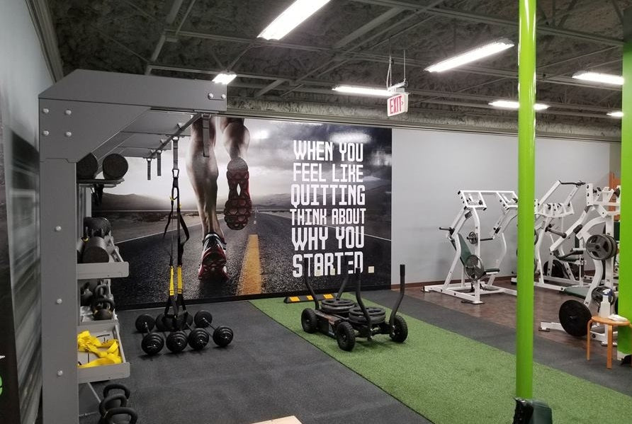 Warrior Firm Turf bright green artificial flooring in gym setting with exercise equipment and motivational signage