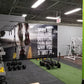 Bright green artificial turf flooring in gym setting with exercise equipment and motivational wall mural