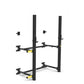 Black and yellow wall-mounted squat rack with dual vertical posts, adjustable arms, and safety spotter positions on white bac