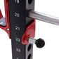 Red and black cable pulley power rack with numbered height markers, chrome bar, and adjustable seat pad, shown on white backg