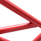 Red steel power rack frame with welded joints and textured grip areas on white background