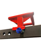 Red metal bench vise with blue knob mounted on black steel base with holes, on white background