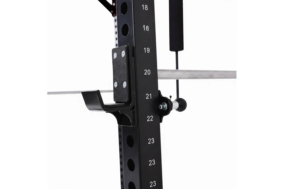 Black steel power rack with numbered adjustment holes, attached black leather shoulder pad and cable pulley attachment with g