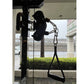 Black cable pulley functional trainer with chain attachment mounted on pole, shown in gym setting with waterfront view