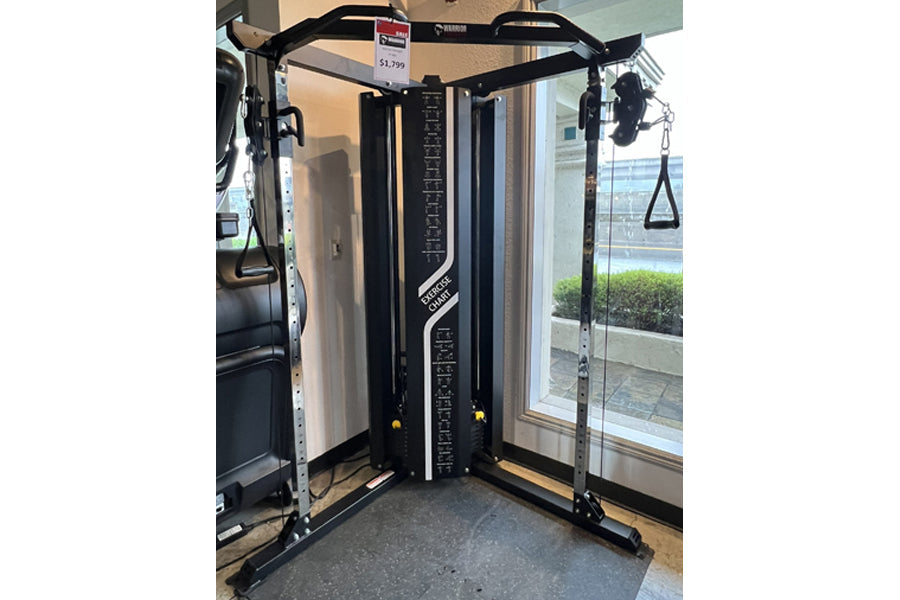 Black and white Warrior FT900 functional trainer with dual cable pulleys and adjustable handles on display in showroom