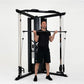 Man using black and silver cable pulley functional trainer with dual weight stacks on white background