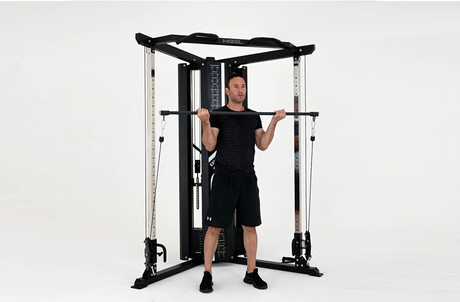 Man using black and silver cable pulley functional trainer with dual weight stacks on white background