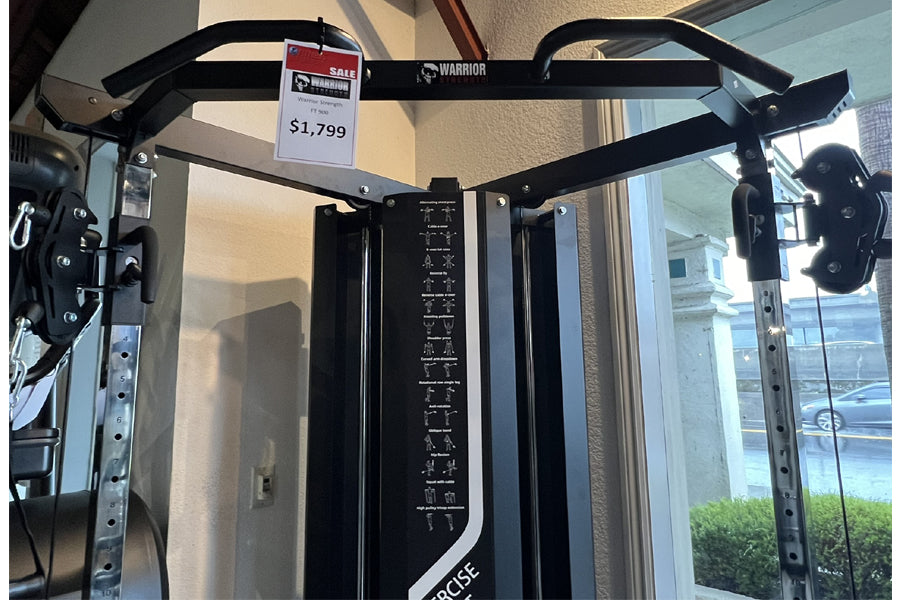 Black Warrior FT900 cable pulley functional trainer with dual weight stacks and adjustable arms, displayed in showroom with s