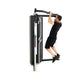 Man in black workout clothes using black cable pulley functional trainer with dual arms on white background