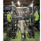 Warrior Gladiator 2.0 black power rack with neon green weight plates, bench, and lat pulldown attachment in gym setting
