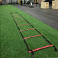 Warrior Gorilla Turf agility ladder with red rungs and black sides on green artificial turf